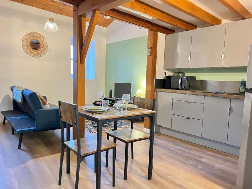 une cuisine et une salle à manger avec une table et des chaises dans l'établissement Les 4 Appartements au cœur de Châtellerault, à Châtellerault