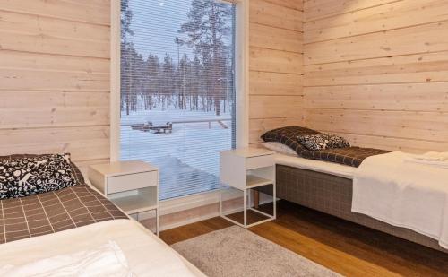 a room with two beds and a large window at Villa Paadari in Inari