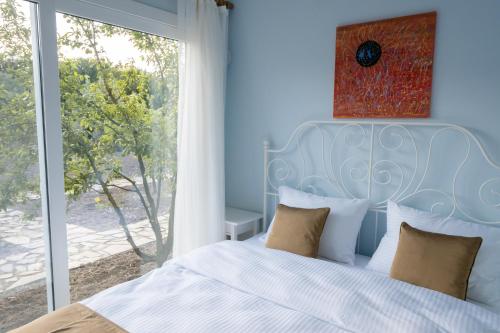 a blue bedroom with a bed and a large window at Gadura Kır Evleri Urla in Urla