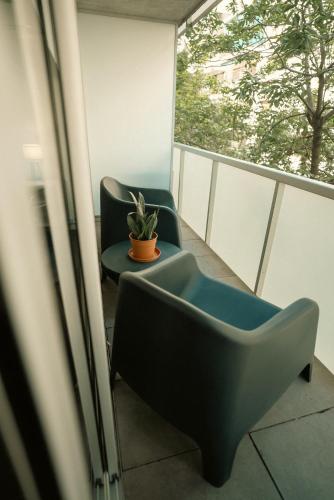 a balcony with two chairs and a potted plant at Sucre Suites in Buenos Aires