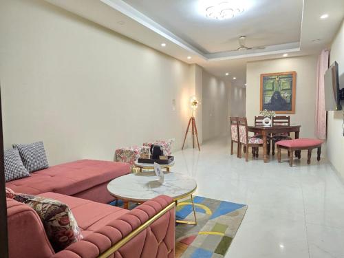 een woonkamer met een bank en een tafel en een eetkamer bij Homlee-Saket Anupam Stylish 3BHK in South Delhi in New Delhi
