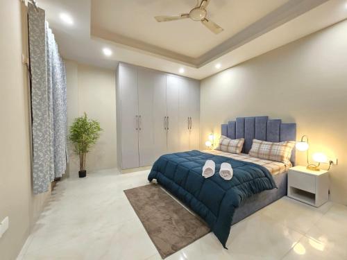 een slaapkamer met een blauw bed en een blauwe deken bij Homlee-Saket Anupam Stylish 3BHK in South Delhi in New Delhi