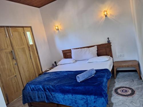 een slaapkamer met een bed met een blauwe deken erop bij Alali Villa in Bentota