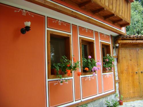 a building with flower boxes on the windows at Guest House Todorini kashti in Koprivshtitsa
