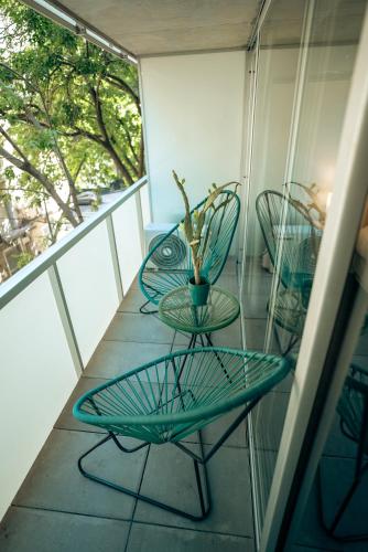 two chairs and a table on a balcony at Sucre Suites in Buenos Aires
