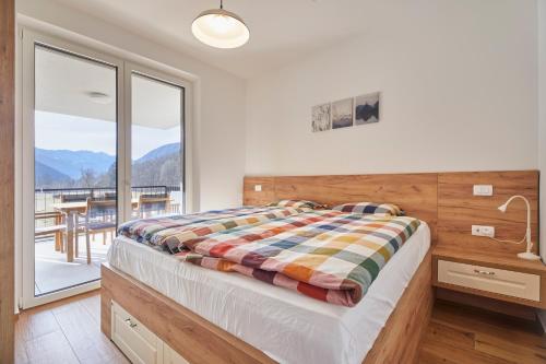 - une chambre avec un lit et une grande fenêtre dans l'établissement Apartments Svitnjak, à Bovec