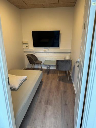 a room with a bed and a desk and a tv at Italian Rooms 10 in Aalborg