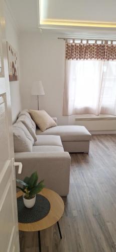ein Wohnzimmer mit einem Sofa und einem Tisch in der Unterkunft Paradise Apartmanház in Eger