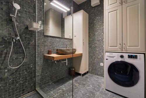 a bathroom with a sink and a washing machine at Apartments Svitnjak in Bovec
