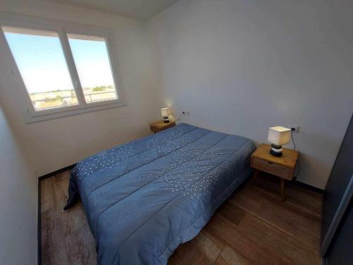 une chambre avec un lit bleu et deux fenêtres dans l'établissement Grau d'Agde : Appartement climatisé 2 chambres à 20m de la plage - FR-1-423-172, au Grau-dʼAgde
