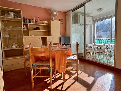une cuisine avec une table et des chaises dans une pièce dans l'établissement Studio cabine 3 pers, 400m plage, pkg privé, animaux OK, loggia, TV, lave-linge, ménage inclus - FR-1-225-634, à Argelès-sur-Mer