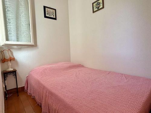 - une chambre avec un lit rose et une fenêtre dans l'établissement Studio cabine 3 pers, 400m plage, pkg privé, animaux OK, loggia, TV, lave-linge, ménage inclus - FR-1-225-634, à Argelès-sur-Mer