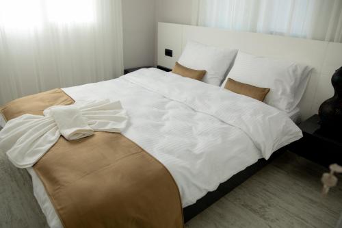a bedroom with a large bed with white sheets and pillows at Gadura Kır Evleri Urla in Urla