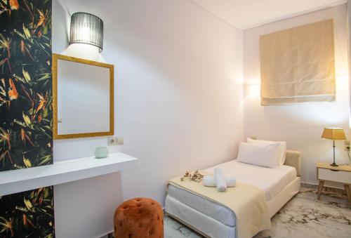 a bedroom with a bed and a mirror and a chair at Zante Harbour Suites with free gym services by "elite" in Zakynthos Town