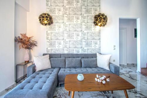a living room with a blue couch and a wooden table at Zante Harbour Suites with free gym services by "elite" in Zakynthos Town