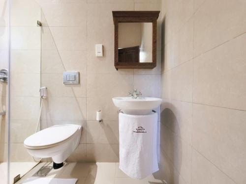 La salle de bains blanche est pourvue d'un lavabo et de toilettes. dans l'établissement Elegant & Peaceful Apartment, à Galu