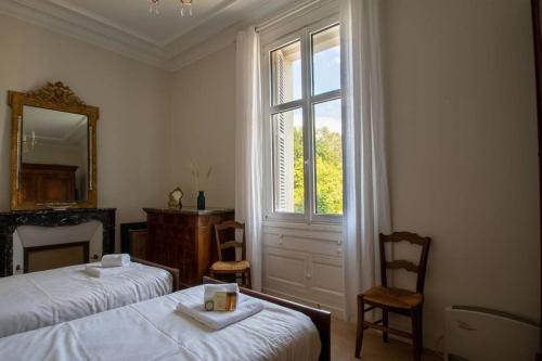 une chambre avec deux lits, un miroir et une fenêtre dans l'établissement Bel appartement avec vue sur la baie de Dinard, à Dinard