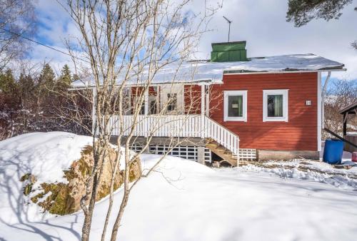 czerwony dom z białym tarasem w śniegu w obiekcie Kesäelo w mieście Porvoo