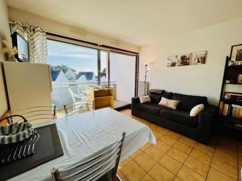 un salon avec une table et un canapé dans l'établissement Charme à Quiberon : 2 pièces cosy, proche plage, balcon sud, parking inclus - FR-1-478-266, à Quiberon