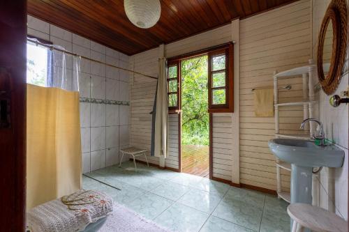 uma casa de banho com um lavatório, um WC e uma janela. em Sítio Águas Encantadas - Cachoeira e Águas termais em Santo Amaro da Imperatriz