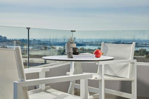 a white table and two chairs with an apple on it at CW Athens Riviera Suite in Athens