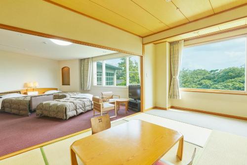 a bedroom with a bed and a large window at KAMENOI HOTEL Fukui in Fukui