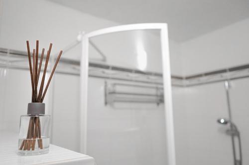 a bathroom with a glass vase with sticks in it at Apartmán u Martina in Žilina