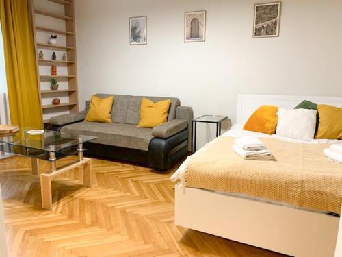 a living room with a bed and a couch at Fancy Life Apartment in Warsaw