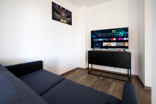 a living room with a blue couch and a flat screen tv at Apartments am Neuen Theater - Altstadt - Zentral - Küche - Wifi - Powered by Ko-Living in Halle an der Saale