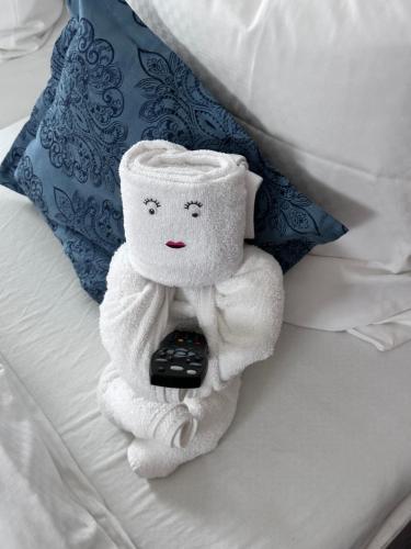 a towel stuffed animal sitting on a bed with a remote control at Hotel Sonne in Weingarten