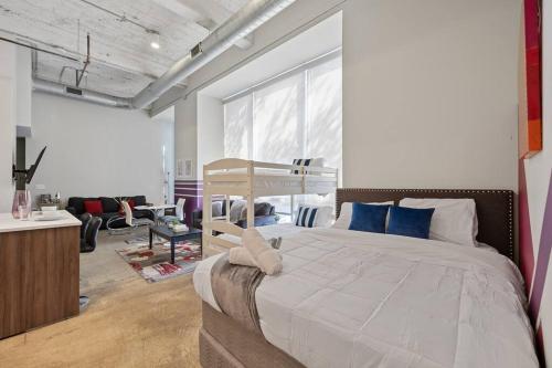 a bedroom with a large white bed with blue pillows at Luxurious Downtown Apt - Pool, Laundry, Parking in Dallas