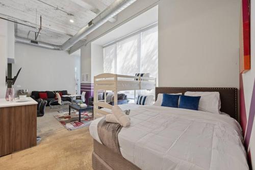 Un dormitorio con una gran cama blanca con almohadas azules. en Stunning Downtown Apartment with Pool, Laundry, Parking, en Dallas