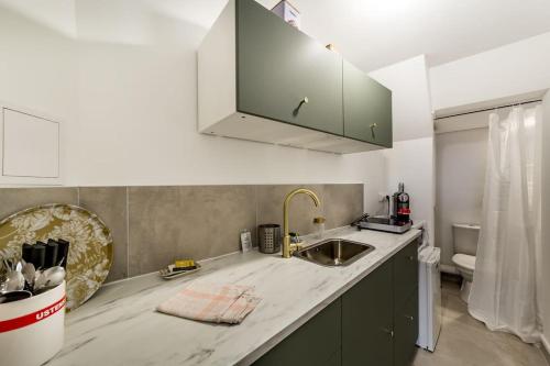 une cuisine avec un évier et un plan de travail dans l'établissement Nouveau studio tout équipé Charbonnières les Bains, à Charbonnières-les-Bains