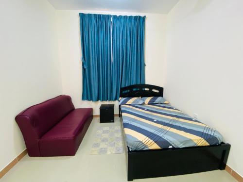 1 dormitorio con cama y silla morada en Serene Nest, en Umm Al Quwain