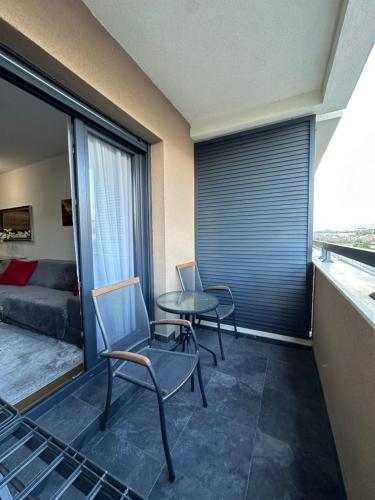 a room with two chairs and a table and a couch at Hill Homes Mal in Podgorica