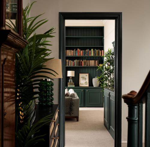 una porta che conduce a un soggiorno con una libreria verde di Brayford House a Lincoln