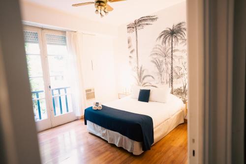 a bedroom with a bed with palm trees on the wall at Sucre Suites in Buenos Aires