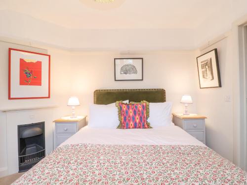 a bedroom with a bed and two lamps and a fireplace at 3 Chantry Cottages in Woodbridge