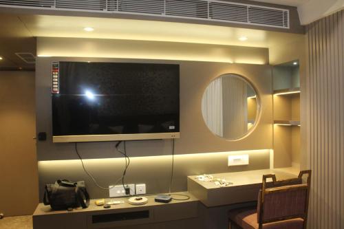 ein Wohnzimmer mit einem TV an der Wand in der Unterkunft Continental Lodge & Continental Residency in Māldah
