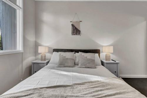 1 dormitorio con 1 cama blanca grande y 2 lámparas en TheWest36 - Sandy Escape en Henley Beach South