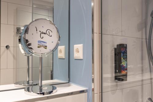 a mirror sitting on a shelf in a bathroom at Holiday Inn-the niu, Wave Karlsruhe Oststadt by IHG in Karlsruhe