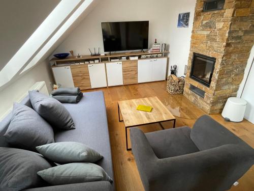 a living room with a couch and a television at Apartmán “U nás v podkroví“ v Rezidenci Klostermann, Železná Ruda 24 in Železná Ruda