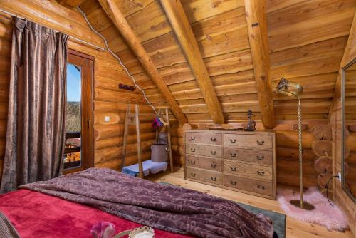1 dormitorio con 1 cama en una cabaña de madera en Rustic villa Roza with outdoor pool in Kupjak, en Kupjak