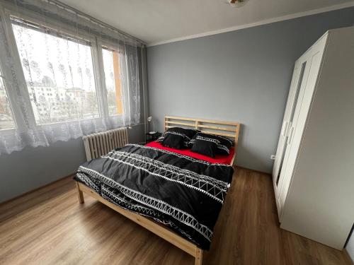 a bedroom with a bed with a black and red blanket at Hoa Stay in Prague