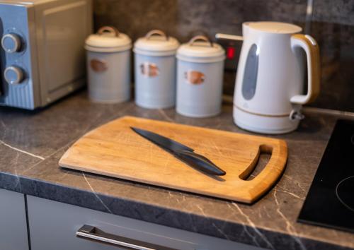 a cutting board with a knife on top of a counter at Oasis studio in the Heart of the City in Brighton & Hove