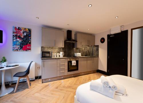 a living room with a kitchen and a table with a chair at Oasis studio in the Heart of the City in Brighton & Hove