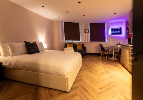 a hotel room with a bed and a table at Modern Studio Oasis in the Heart of the City in Brighton & Hove