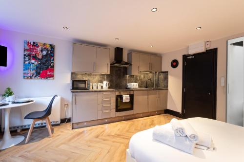 a room with a kitchen with a table and a tableablish at Modern Studio Oasis in the Heart of the City in Brighton & Hove