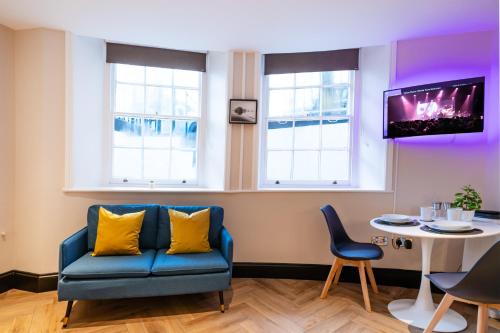 a living room with a blue couch and a table at Oasis studio in the Heart of the City in Brighton & Hove