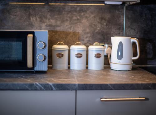 a row of coffee cups sitting next to a microwave at Oasis studio in the Heart of the City in Brighton & Hove